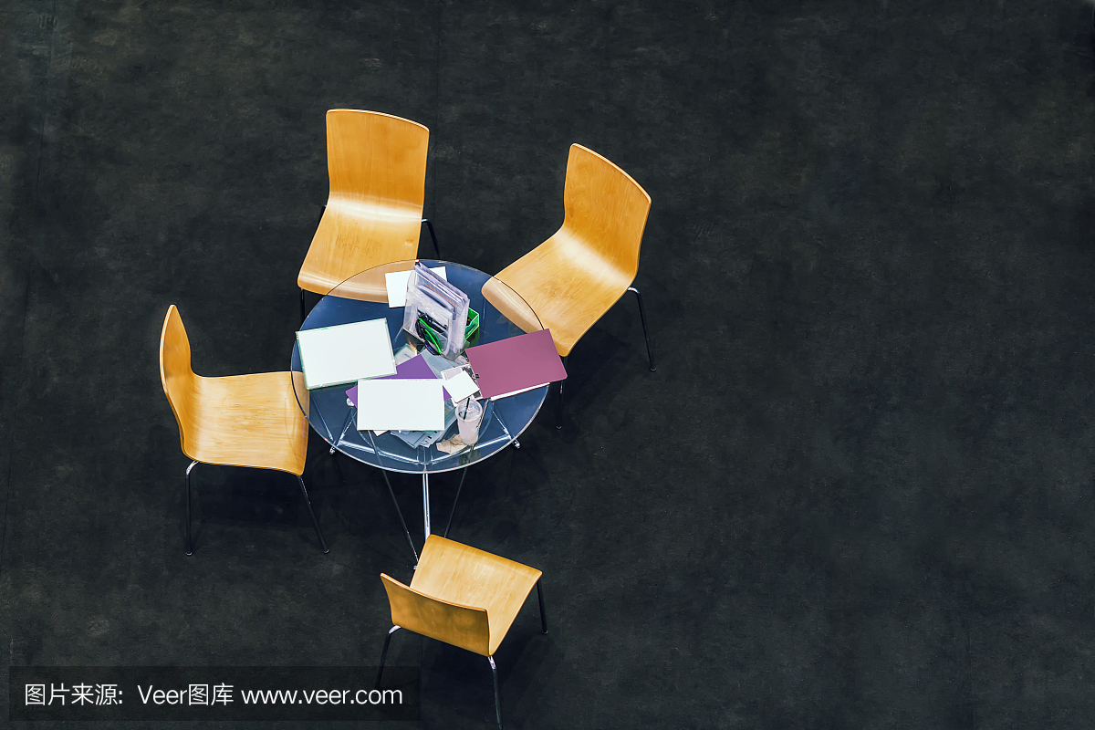 俯视图的一个小型商业会议圆桌与四把椅子在黑色地板上的拷贝空间